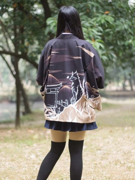 Une femme de dos montre son kimono au motif d'un loup dans la nuit japonaise
