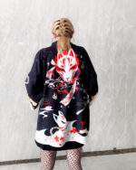 Une femme de dos montre son kimono de couleur noir avec un motif imprimé de renard en rouge et blanc