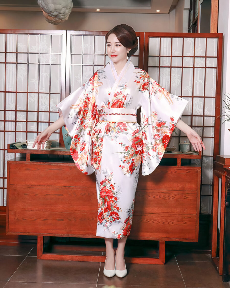 19211-d7d96f.jpeg Femme de tipe asiatique portant un kimono traditionnel, floral, blanc et rouge se tenant debout dans un salon japonais.