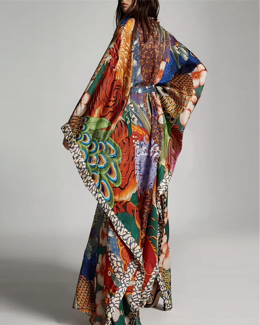 Femme brune debout qui porte un kimono de plage avec des motifs chinois de dragon, elle se tient de dos et est tourné à trois quarts