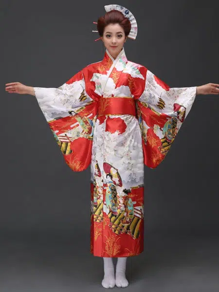 Une femme porte un kimono rouge et blanc avec des motifs japonais à manches larges, ses cheveux sont coiffés en chignons traditionnels, ses bras son ouverts de part et d'autre