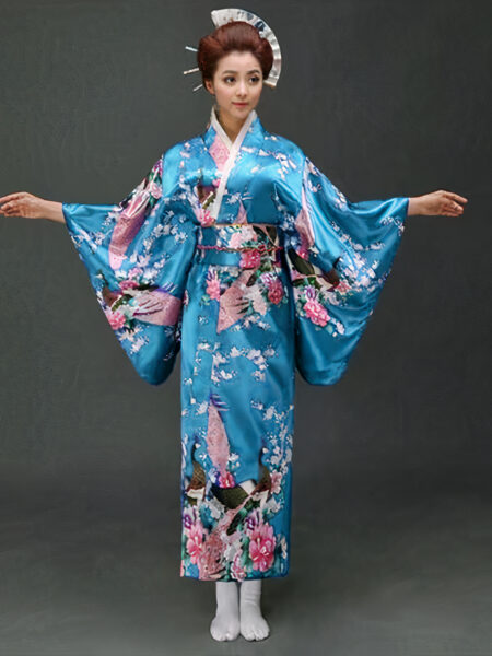Une femme porte un kimono bleu turquoise avec des motifs japonais à manches larges, ses cheveux sont coiffés en chignons traditionnels, ses bras son ouverts de part et d'autre
