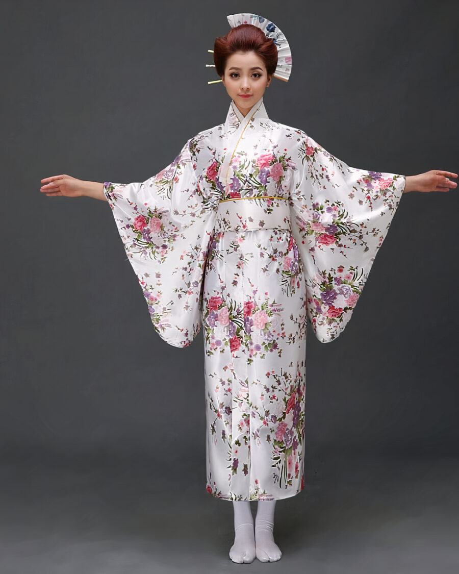 Une femme porte un kimono blanc avec des motifs japonais à manches larges, ses cheveux sont coiffés en chignons traditionnels, ses bras son ouverts de part et d'autre