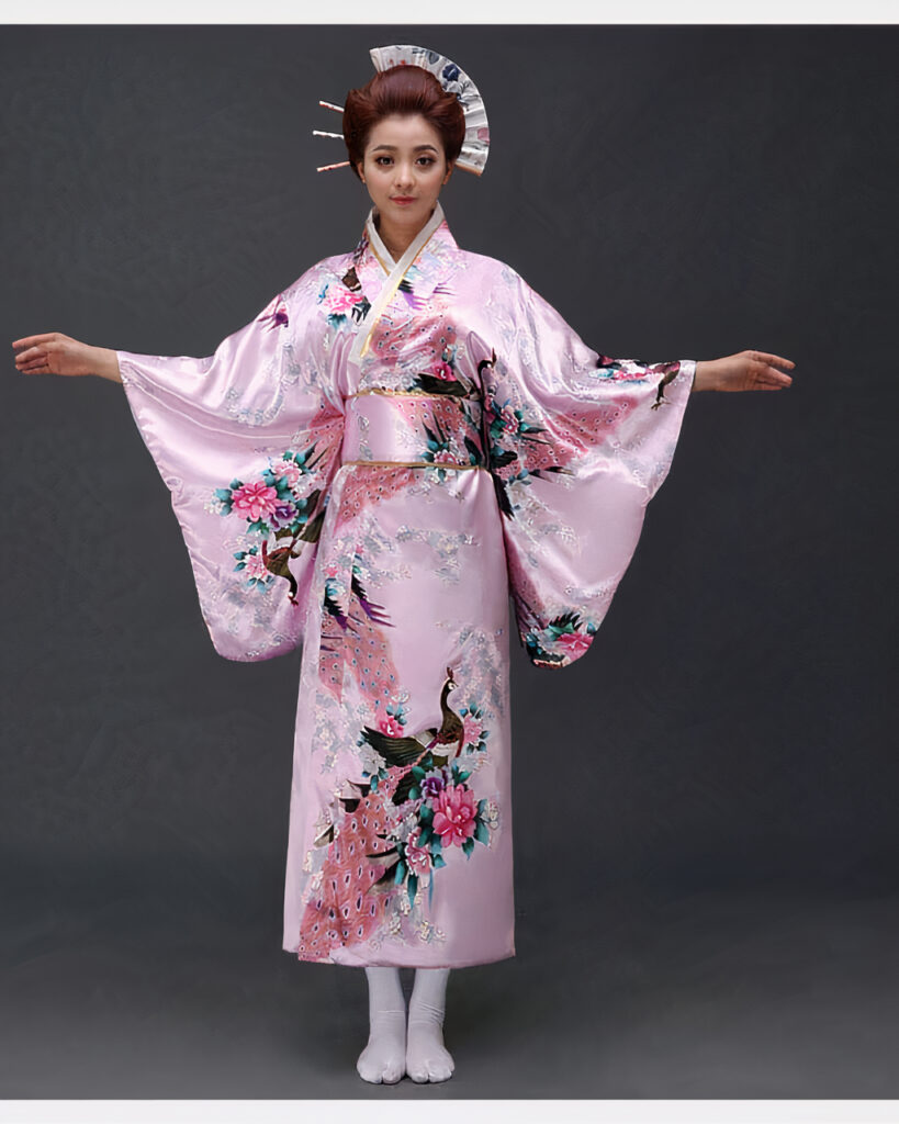 Une femme porte un kimono rose pastel avec des motifs japonais à manches larges, ses cheveux sont coiffés en chignons traditionnels, ses bras son ouverts de part et d'autre