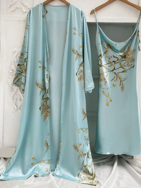 Ensemble nuisette et kimono bleu à imprimé floral suspendus à des cintres devant un mur blanc avec des moulures et sur un drap blanc