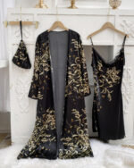 Ensemble nuisette et kimono noir à imprimé floral suspendus à des cintres devant un mur blanc avec des moulures et sur une couverture fourrure blanche