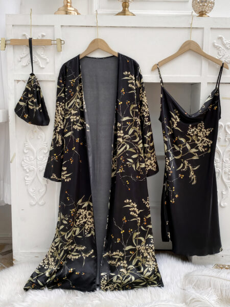 Ensemble nuisette et kimono noir à imprimé floral suspendus à des cintres devant un mur blanc avec des moulures et sur une couverture fourrure blanche