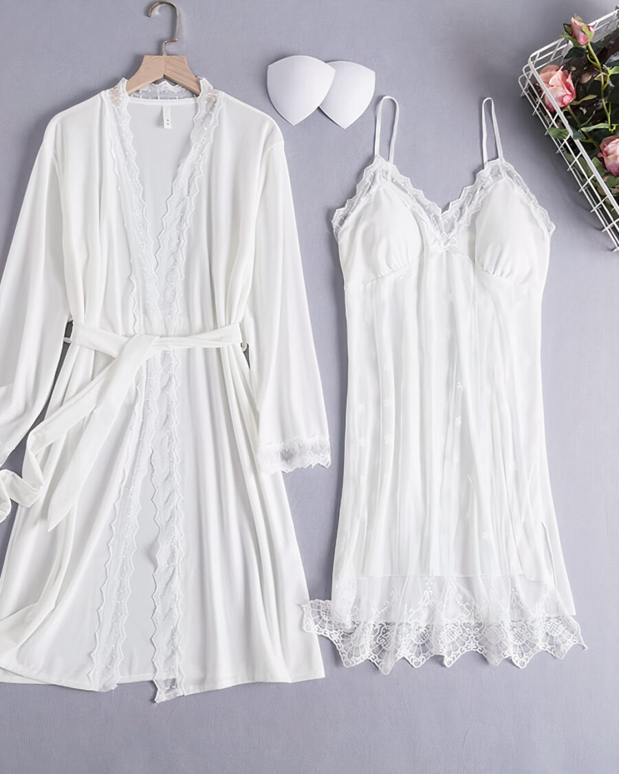 Ensemble nuisette et kimono blanc en velours posés à côté d'un panier de fleurs roses sur un sol gris