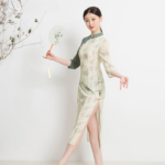 Robe japonaise beige à motifs fleuris verts, portée par une femme avec un éventail