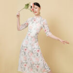 Robe japonaise de couleur blanche à motifs roses, portée par une femme dansant avec une rose