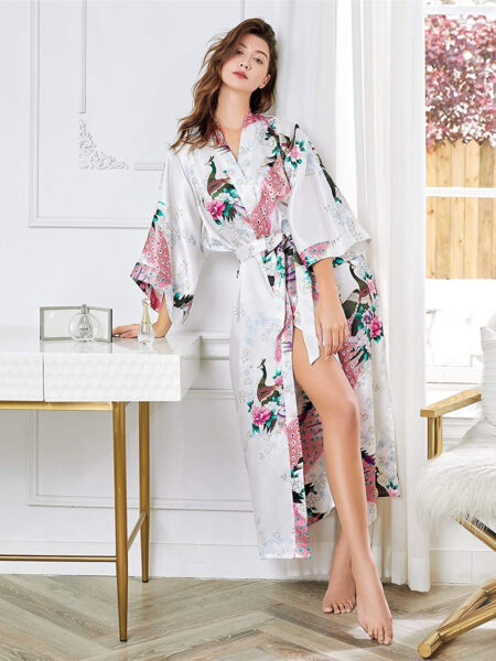 Kimono japonais femme bleu à motif de paon, porté par une femme adossée à un bureau blanc