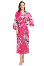 Kimono japonais femme rose à motif de paon, porté par une femme debout