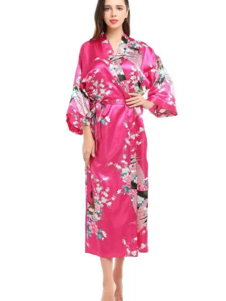 Kimono japonais femme rose à motif de paon, porté par une femme debout