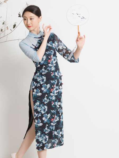 Robe japonaise bleue à motifs fleuris blancs, portée par une femme avec un éventail