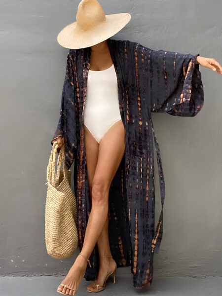 Kimono d'été long pour femme sur une femme portant un chapeau beige et un body blanc en dessus devant un mur gris