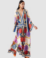 Robe kimono longue chic pour femme à motifs fleuris orientaux porté par une femme brune sur un fond gris clair uni