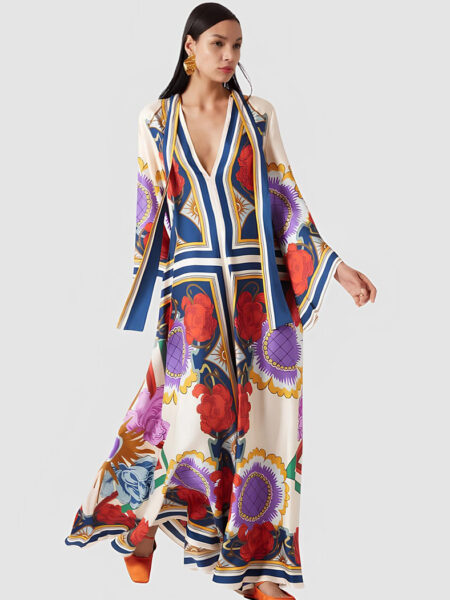 Robe kimono longue chic pour femme à motifs fleuris orientaux porté par une femme brune sur un fond gris clair uni