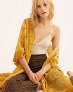 Femme portant un kimono jaune au style bohème sur fond blanc