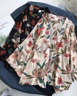 Kimono court à motif fleuri en coloris beige et noir posés à plat sur le sol flatlay