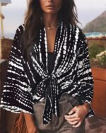 Femme portant un kimono court noué à la taille dans un imprimé noir et blanc