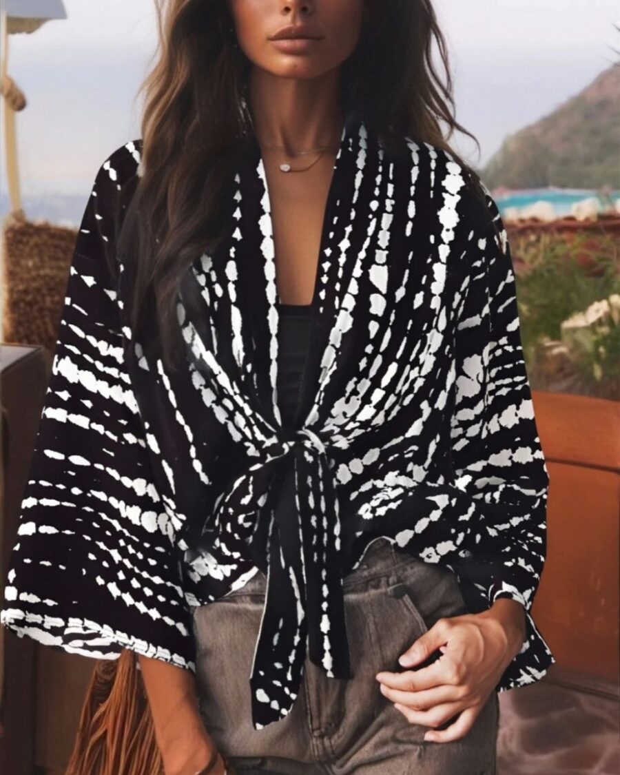Femme portant un kimono court noué à la taille dans un imprimé noir et blanc