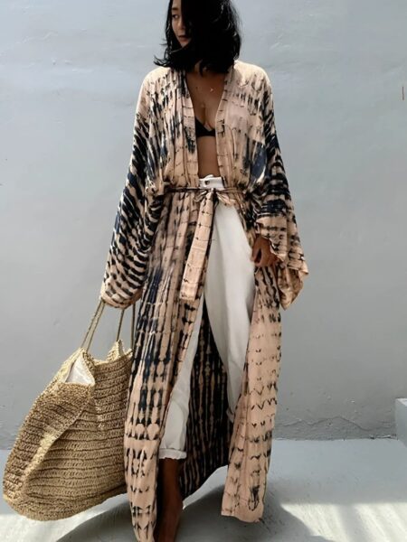 Femme portant un kimono de plage tie and dye beige et noir sur fond gris