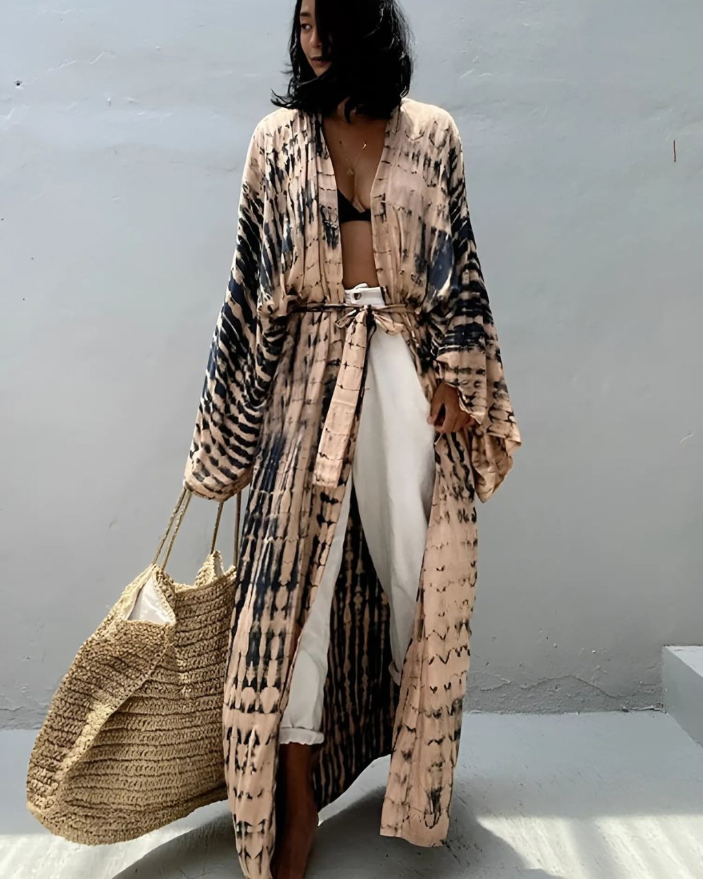 Femme portant un kimono de plage tie and dye beige et noir sur fond gris