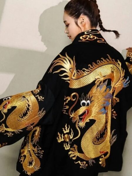 Femme portant un kimono noir avec un motif dragon doré sur fond beige