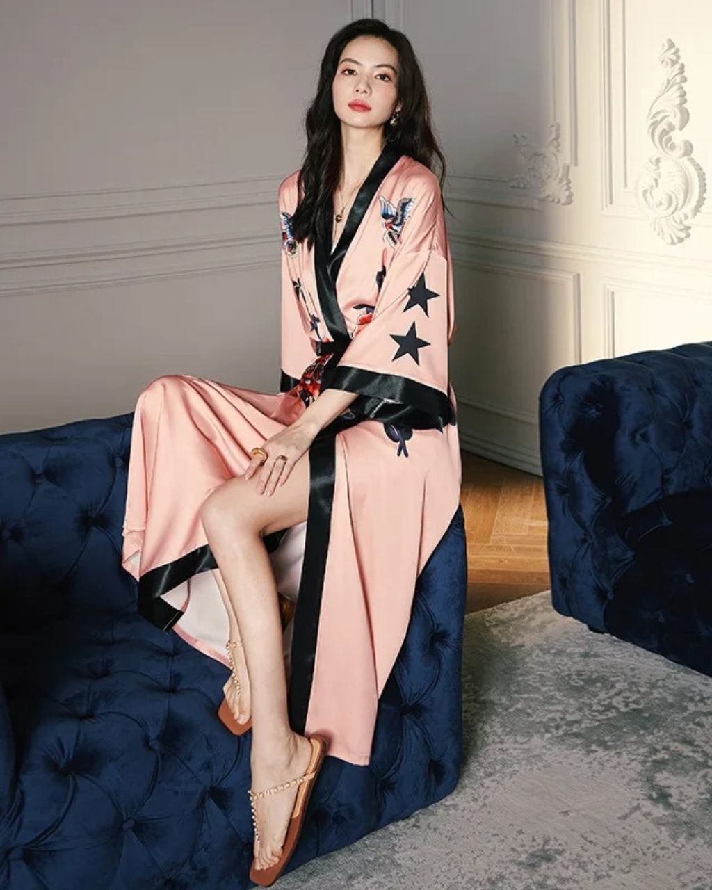 Femme assise sur un canapé portant un peignoir kimono long en satin rose