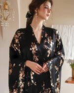 Femme portant un peignoir kimono en satin noir dans une chambre