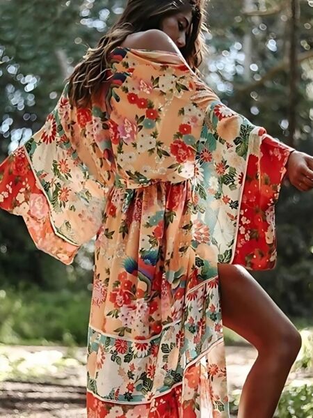 Femme portant un kimono long fleuri au style bohème de couleur orange dans un jardin